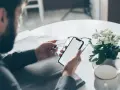 Mężczyzna z kartą płatniczą i telefonem, przygotowuje się do transakcji. Czy to początek jego bitcoin profit recenzja?