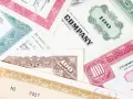 Różnorodne akcje total SA, z numerami 100 i innymi oznaczeniami, tworzą kolorowy kolaż.