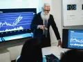Starszy mężczyzna z brodą analizuje wykresy, omawiając strategię inwestycyjną. Sony akcje rosną!