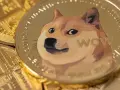 Złota moneta z wizerunkiem psa Shiba Inu i napisem "WOW". W tle widać inne monety, tworząc obraz symbolizujący dogecoin wykres.