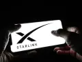Dłonie trzymają smartfon z logo Starlink. Zainteresowanie **starlink akcje** rośnie.