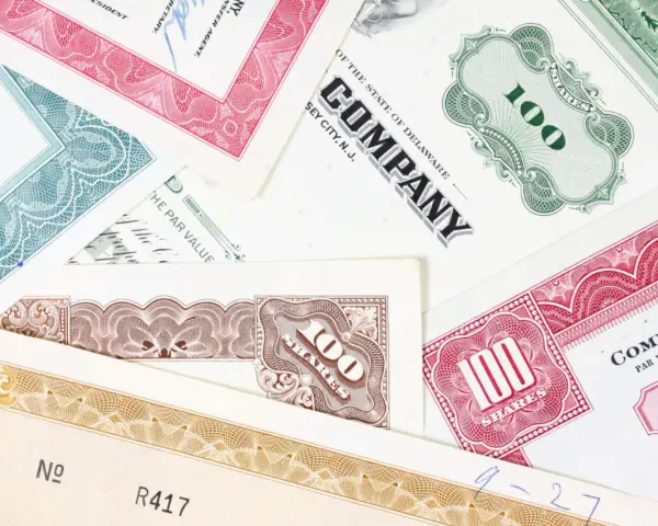 Różnorodne akcje total SA, z numerami 100 i innymi oznaczeniami, tworzą kolorowy kolaż.