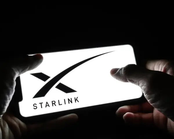 Dłonie trzymają smartfon z logo Starlink. Zainteresowanie **starlink akcje** rośnie.