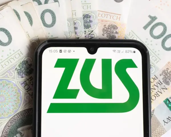 Smartfon z logo ZUS na tle banknotów 100 zł. Informacja o ulgach dla młodych przedsiębiorców, którzy prowadzą działalność gospodarczą do 26 roku życia, zus.