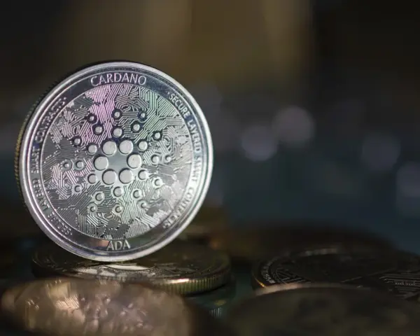 Moneta Cardano (ADA) na stosie innych monet. W tle rozmyte światła, sugerujące analizę i prognozy dotyczące przyszłości kryptowaluty.