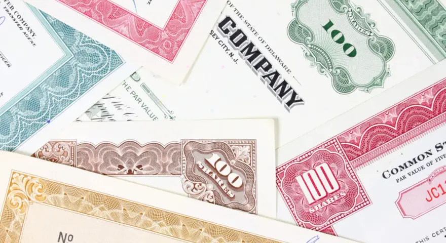 Różnorodne akcje total SA, z numerami 100 i innymi oznaczeniami, tworzą kolorowy kolaż.