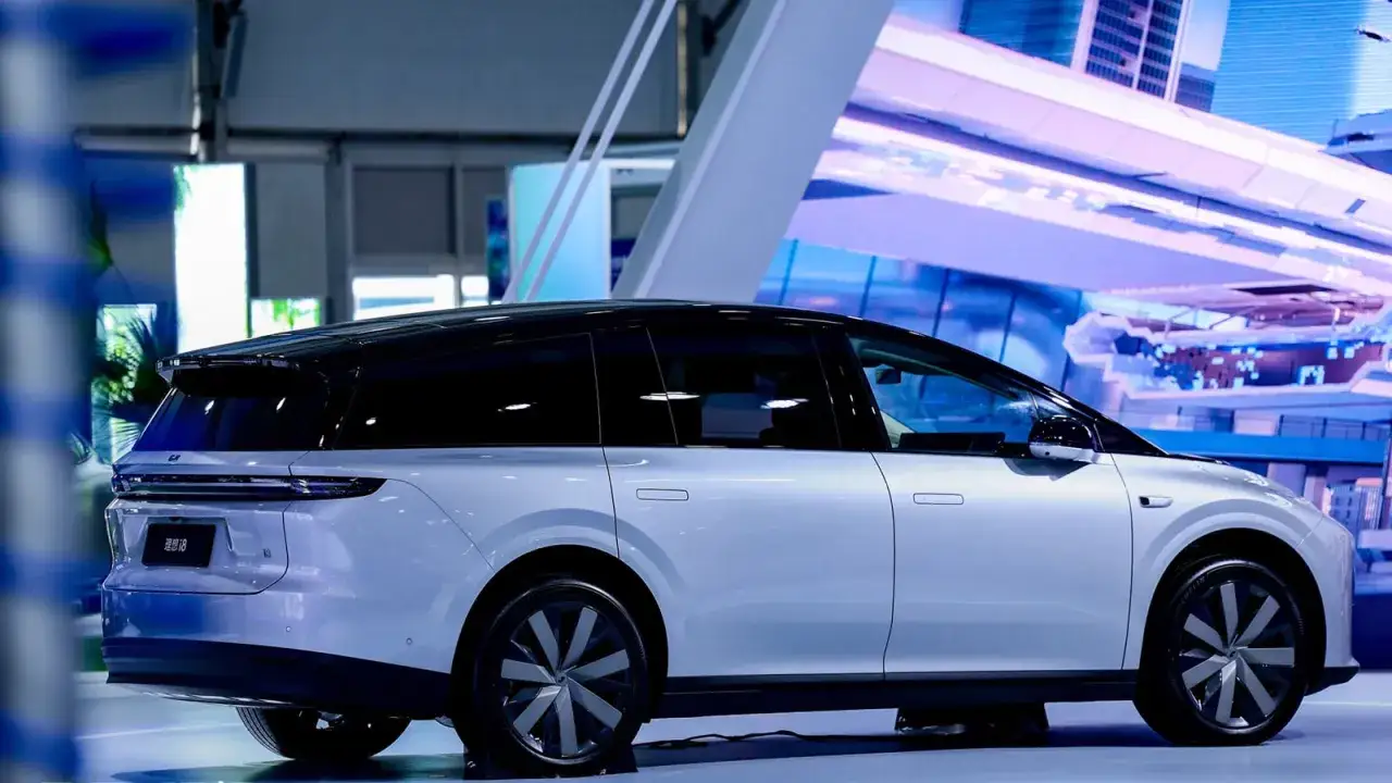 Srebrny minivan z czarnym dachem, z napisem 